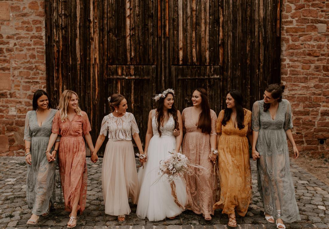 Fall Wedding Inspuiration - Bridesmaids holding hands in rich colored fall dresses